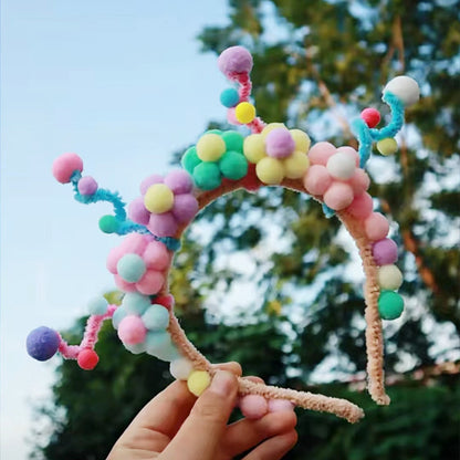 Top view of Kaca party headband showing the arrangement of colorful pom-poms