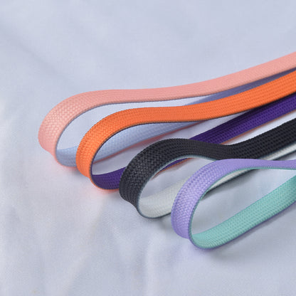 Brightly colored shoe laces coiled neatly on a white background