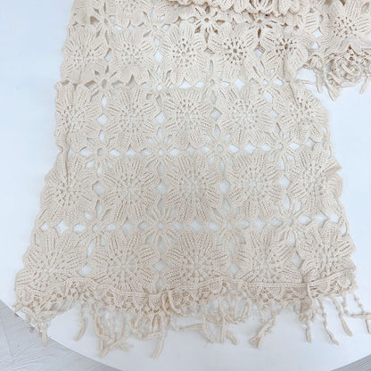 Boho crochet shawl scarf folded on wooden surface showing texture