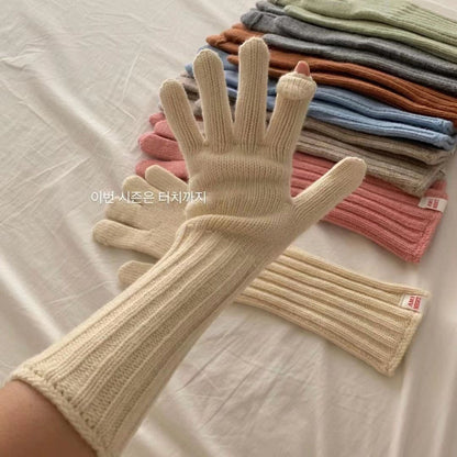 Pair of winter gloves with long knitted sleeves in light gray on white background