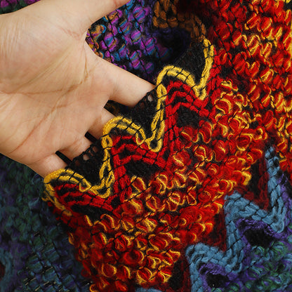 Close-up of the shawl's textured fabric and pocket detail in beige and brown colors