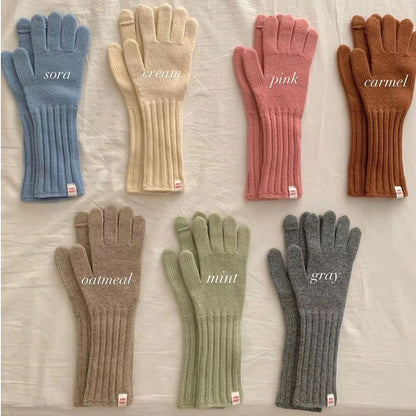 Model wearing gray winter knitted gloves with sleeves outdoors
