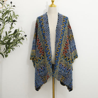 Folded boho shawl with pocket displayed on a wooden surface